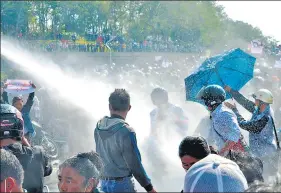  ?? AFP ?? (Above ) Police use water canon against protesters in Naypyidaw. (Left) Protesters gather to demonstrat­e against the February 1 military coup, in downtown in Yangon on Monday.