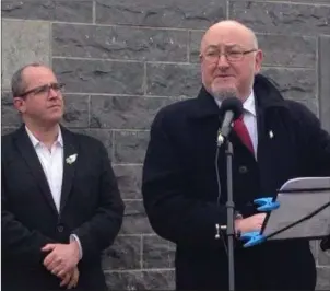  ??  ?? Sligo County Councillor Chris MacManus looks on as Deputy Caoimhghin Ó Caoláin delivers his oration at the Republican Plot in Sligo Cemetery on Easter Sunday.