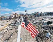  ??  ?? An American flag flies Thursday amid destructio­n in the aftermath of Hurricane Michael in Mexico Beach, Fla.