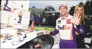  ?? Jared C. Tilton / Getty Images ?? Denny Hamlin poses in Victory Lane after winning Sunday at Kansas Speedway.