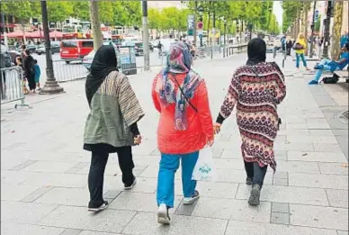  ?? ALAMY STOCK PHOTO ?? Tres mujeres musulmanas de compras por los Campos Elíseos de París