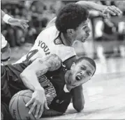  ??  ?? Richmond guard Darien Brothers (bottom) and Kansas forward Kevin Young hit the floor to wrestle for the loose ball during Tuesday’s game.