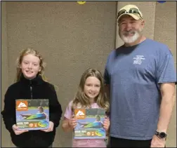  ?? ?? Magnet Cove fourth graders Kaitlynn Dickinson and Carissa Burkett show off their door prizes next to Tony Jenkins of Arkansas Getting Everyone Outside (GEO.)