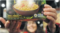  ?? JASON PAYNE/ PNG FILES ?? Teresa Lynne, volunteer with GE Free BC, holds a box of Nature’s Path certified organic and non- GMO cereal at Pomme Natural Market in Port Coquitlam.