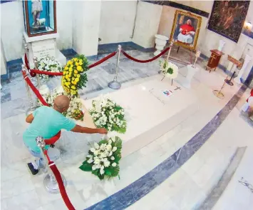  ?? PAUL JUN ROSAROSO ?? A Catholic faithful reaches out to touch the tomb of Cebu’s Archbishop Emeritus Ricardo Cardinal J. Vidal in the mausoleum at Cebu Metropolit­an Cathedral.