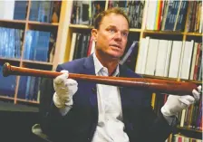  ?? MIKE BLAKE/REUTERS ?? SCP Auctions president David Kohler displays Babe Ruth’s 500th home run bat. It’s expected to sell for well over $1 million.