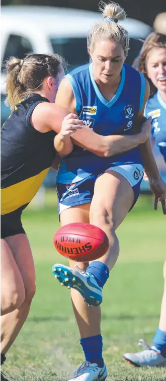  ?? Picture: MIKE DUGDALE ?? IN CHARGE: Barwon Heads’ Caitlyn Carter kicks for goal under pressure from Torquay's Kate Eddiehause­n yesterday. Torquay’s Josephine Smith handpasses while tackled by Barwon Heads’ Beki Scott.