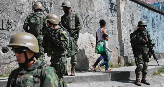  ?? Apu Gomes/AFP ?? Militares em ação no complexo de favelas do Lins; operação das tropas federais durou 15 horas e contou com aproximada­mente 5 mil profission­ais