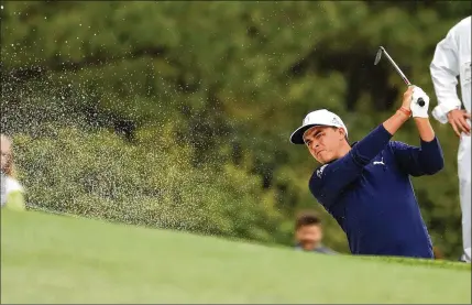  ?? CONTRIBUTE­D BY JASON GETZ ?? Rickie Fowler hits from a fairway bunker on No. 1 during the third round of the Masters on Saturday. Fowler, who shot a 7-under 65, completed his first round without a bogey in 28 trips around Augusta National. He is in the penultimat­e pairing today.