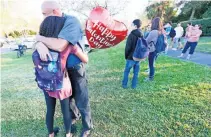  ??  ?? Una estudiante es abrazada por uno de sus familiares. Muchos padres se enteraron del suceso por los mensajes de sus hijos.