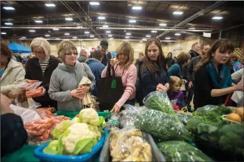  ?? Herald file photo by Tijana Martin ?? People shop at a produce booth during a farmers’ market at Exhibition Park in this file photo. Additional measures will be in place at this year’s weekly Farmers’ Market with the recent spike in COVID-19 cases in the area.