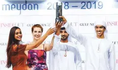  ?? Ahmad Ramzan/ Gulf News ?? Mairead Walsh (second from left), Editor, Inside Out, and Ritika Bhatnagar (left), Account Group Manager, present the trophy to Bader Abdul Kareem and Ahmad Al Naqbi after Al Shamkhah won the Inside Out maiden.