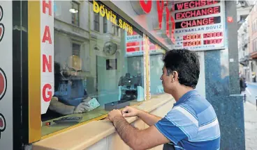  ?? /Reuters ?? Lira lurch: A man changes money at a currency exchange office in Istanbul on Monday, when the lira fell to a record low of 7.2362 to the dollar. Despite calls for Turkey to hike interest rates, President Recep Tayyip Erdogan is standing firm against this move.