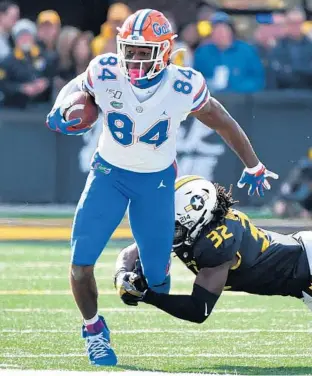  ?? GETTY ?? Gators tight end Kyle Pitts tries to avoid a tackle by Missouri linebacker Nick Bolton in 2019.