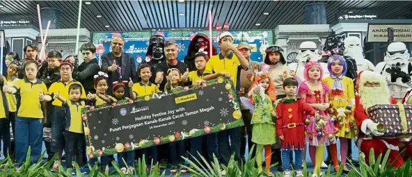  ??  ?? Fun and laughter: MAHB and Maybank officials, and children from Pusat Penjagaan Kanak-Kanak Cacat Taman Megah with the members of 501st Legion Malaysia Garrison and FightSaber at the event.