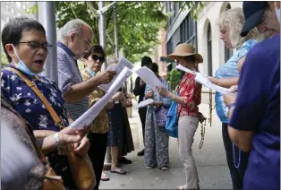  ?? SETH WENIG - THE ASSOCIATED PRESS ?? A group of Catholics pray outside a public library during a Drag Story Hour in New York, Friday. The “rosary rally” was in protest of the drag story time.