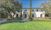  ?? ?? AN ARCHED door sets a stately tone, leading to formal spaces such as a two-story foyer with herringbon­e f loors and a living room with crystal chandelier.