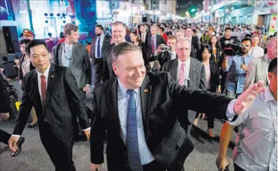  ?? Andrew Harnik ?? Secretary of State Mike Pompeo waves Sunday as he walks through the streets of Hanoi, Vietnam. The Associated Press