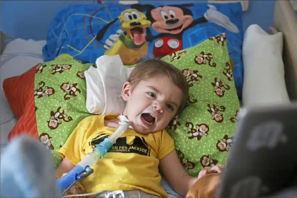  ?? Jessie Wardarski/Post-Gazette ?? Jackson Beck, 2, who was diagnosed with acute flaccid myelitis, growls at his iPad as he watches one of his favorite cartoons Sunday at the Children's Home of Pittsburgh in Bloomfield.