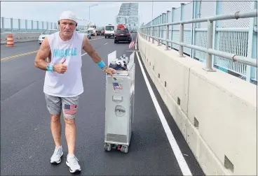  ?? Josh LaBella / Hearst Connecticu­t Media ?? Paul Veneto crosses the Arrigoni Bridge from Portland into Middletown on Tuesday during his trek, dubbed Paulie’s Push, from Boston Airport to ground zero in New York. He’s raising money for a nonprofit helping people with addiction and others that support families of the flight attendants who died on 9/11.