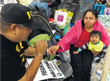  ?? THE ASSOCIATED PRESS ?? Alain Cisneros, a community organizer for the Immigrant Families and Students in the Struggle, an advocacy group known by its Spanish acronym FIEL, speaks with Adabella Fonseca, a Mexican woman whose parents brought her to the U.S. illegally when she...