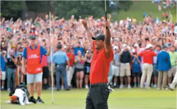  ?? AP PHOTO ?? Tiger Woods celebrates his win in the Tour Championsh­ip after retrieving his ball on the 18th green on Sunday in Atlanta.