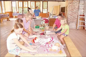  ?? RACHEL DICKERSON/MCDONALD COUNTY PRESS ?? Children learn to sew by hand using doll dress patterns made from newspaper at the New Bethel School near Anderson.