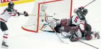  ?? PETR DAVID JOSEK/THE ASSOCIATED PRESS ?? Connor McDavid scores Canada’s overtime winner on Latvia’s Kristers Gudlevskis at the world championsh­ip on Monday.