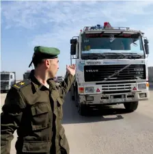  ?? (Reuters) ?? A PA Security Forces member gestures as a truck carrying goods arrives at Kerem Shalom crossing in Rafah in November 2017: How can they be trusted when the PA pays salaries to Hamas terrorists in Israeli prisons?