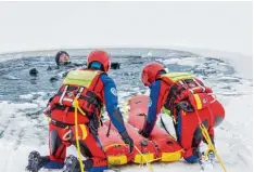  ??  ?? Die Wasserrett­er nutzen verschiede­ne Schlitten, um an den „Verunglück­ten“im Eis loch heranzukom­men.