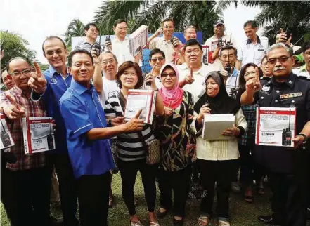  ??  ?? Connected: Loo (second from left), Mohamad Satim (third from left) and Abdul Razak (far right) with the residents from Pusat Bandar Puchong and Bandar Puteri Puchong who received the walkie-talkies