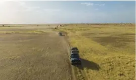  ?? MATT IRVING ?? Following a trail, three expedition Land Rovers head a vehicle train that numbers 15 in all, counting the escort and truck filled with supplies.