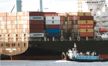  ?? Getty Images ?? Cargo containers sit stacked on a ship on November 22, 2021 in Bayonne, New Jersey.
Firms squeezed by bottleneck­s
—