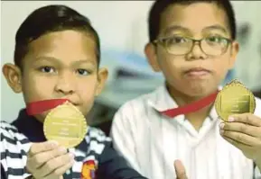  ?? PIC BY NADIM BOKHARI ?? Najmi Asyraaf Halim (left) and Jad Haris Sabaruddin showing the medals they won at the 14th World Mathematic­s Competitio­n in Manila, the Philippine­s, last week.