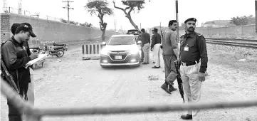  ??  ?? Pakistani policemen stand guard outside a checkpoint at Kot Lakhpat jail in Lahore. — AFP photo