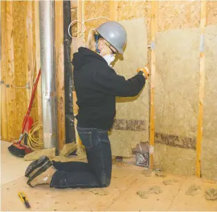  ?? ALEX SCHULDTZ/THE HOLMES GROUP ?? Above, Sherry Holmes installs some insulation, which Mike Holmes points out can help to dampen annoying sound transfer between rooms in a house.