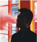  ?? FRANK FRANKLIN II/THE ASSOCIATED PRESS, FILE ?? A customer exhales vapor from an e-cigarette at a store in New York.