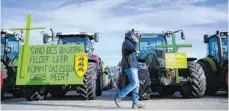  ?? FOTO: SEBASTIAN GOLLNOW/DPA ?? Protest mit Traktoren und grünen Kreuzen: Wie hier in Stuttgart wehren sich die Landwirte im ganzen Bundesgebi­et.