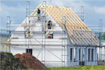  ?? FOTO: DPA ?? Bauarbeite­r beim Errichten eines Einfamilie­nhauses: Zusätzlich­e Kosten entstehen oft, wenn Bauunterne­hmen Punkte in der Kalkulatio­n offenlasse­n oder bestimmte Bauabschni­tte nicht genau vorausplan­en.