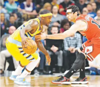  ??  ?? Nuggets guard Ty Lawson, left, contemplat­es his next move as Chicago Bulls guard Kirk Hinrich defends during the first quarter of Tuesday night’s game at the Pepsi Center. Lawson finished with 20 points and a game-high 12 assists as the Nuggets beat...