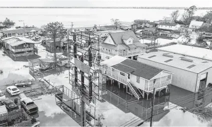  ?? Steve Helber / Associated Press ?? Floodwater­s surround storm-damaged homes in Lafourche Parish, La., as residents try to recover from the effects of Hurricane Ida. The federal government rolled out a new program to calculate flood insurance rates that it says will be more precise and fair.