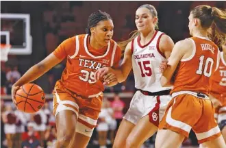  ?? AP PHOTO/GARETT FISBECK ?? Texas forward Madison Booker (35) drives as Oklahoma Sooners guard Lexy Keys defends and Longhorns teammate Shay Holle (10) sets a pick during a Big 12 matchup on Feb. 28 in Norman, Okla.