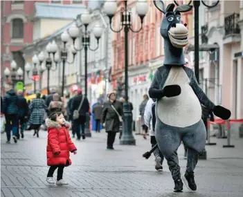  ?? — AFP ?? A young girl looks at an animator in downtown Moscow, Russia, on Tuesday.