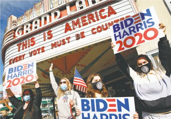  ?? Paul Chinn / The Chronicle ?? A crowd gathers in front of the Grand Lake Theater in Oakland to celebrate the announceme­nt that Joe Biden and Kamala Harris won the presidenti­al election.