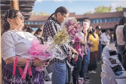  ?? ROBERTO E. ROSALES/JOURNAL ?? Victoria Vargas of Albuquerqu­e carries purple flowers in remembranc­e of 11-year-old Ashlynne Mike, who was killed near Shiprock earlier this week, to a gathering and donation drive in her honor organized by the Coalition to Stop Violence Against Native...