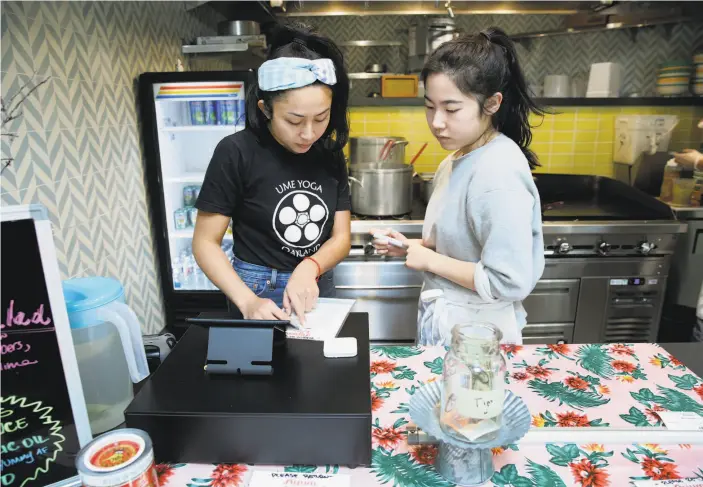  ?? Santiago Mejia / The Chronicle ?? Nite Yun (left) and Jen Won work at Nyum Bai, a Cambodian food stall Yun opened in Emeryville with support from a nonprofit kitchen incubator.