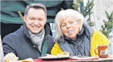  ?? FOTO: HERMANN HUMMEL ?? Willkommen­e Stärkung für Pfarrer Walkler Caxilé und Maria Kruse beim Kirchdorfe­r Weihnachts­markt im Bürgerpark.