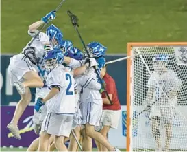  ?? AMY DAVIS/BALTIMORE SUN ?? St. Mary’s players mob goalkeeper Zack Overend, center, after beating Calvert Hall, 12-9, in an MIAA A Conference semifinal on Tuesday.