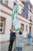  ?? FOTO: JOSEF SCHNEIDER ?? OB Michael Dambacher hisst vor dem Ellwanger Rathaus die Flagge der Mayors for Peace, der Bürgermeis­ter für den Frieden.