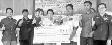  ??  ?? Kurup (centre) presenting a mock cheque to the chairman of the KRT Tiulon Youth Scheme Block A, Larry Aling (third left), during his visit to Sook on Saturday.
